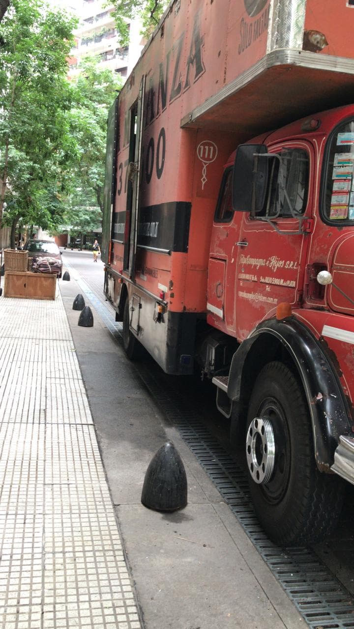 Camión de mudanza La Mudanza estacionado en calle arbolada de CABA