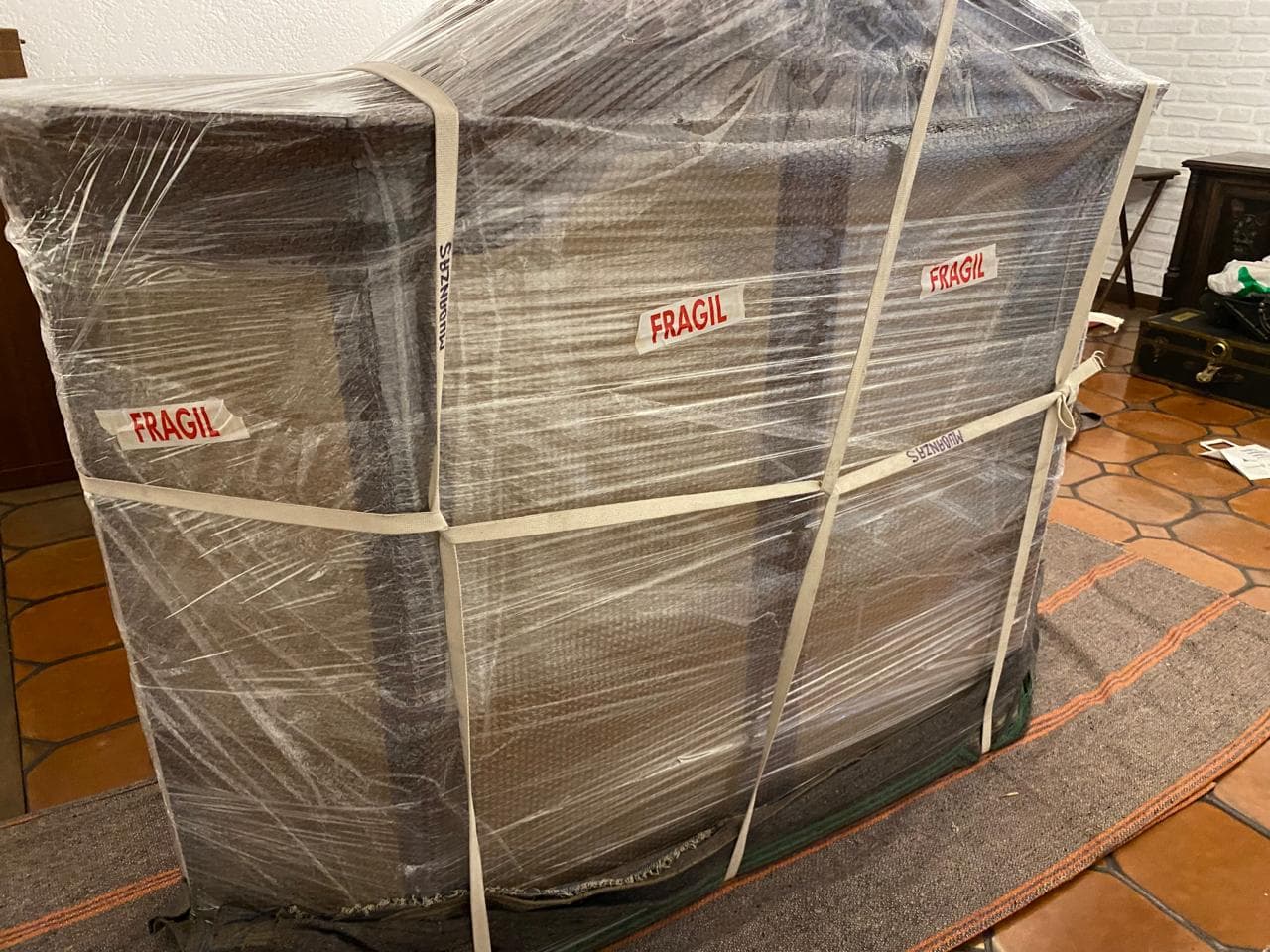 Mueble embalado con carteles FRAGIL y film burbuja para mudanza